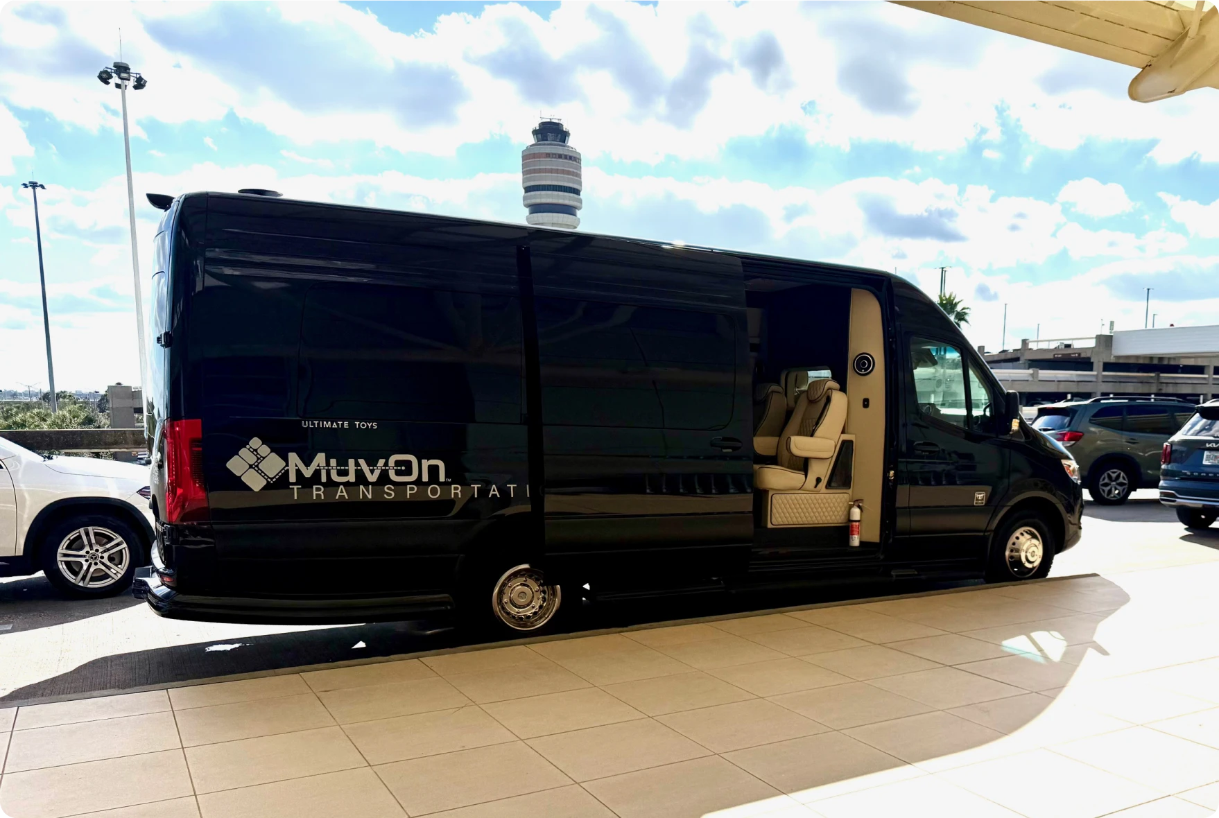 Black transport van parked outside airport terminal